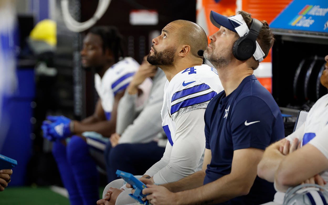 Dallas Cowboys quarterback Dak Prescott (left) and offensive coordinator Brian Schottenheimer (right) watch a replay on the video board from the bench during an NFL wild-card playoff football game against the Green Bay Packers Sunday, Jan. 14, 2024 in Arlington, Texas. The Packers defeated the Cowboys, 48-32.