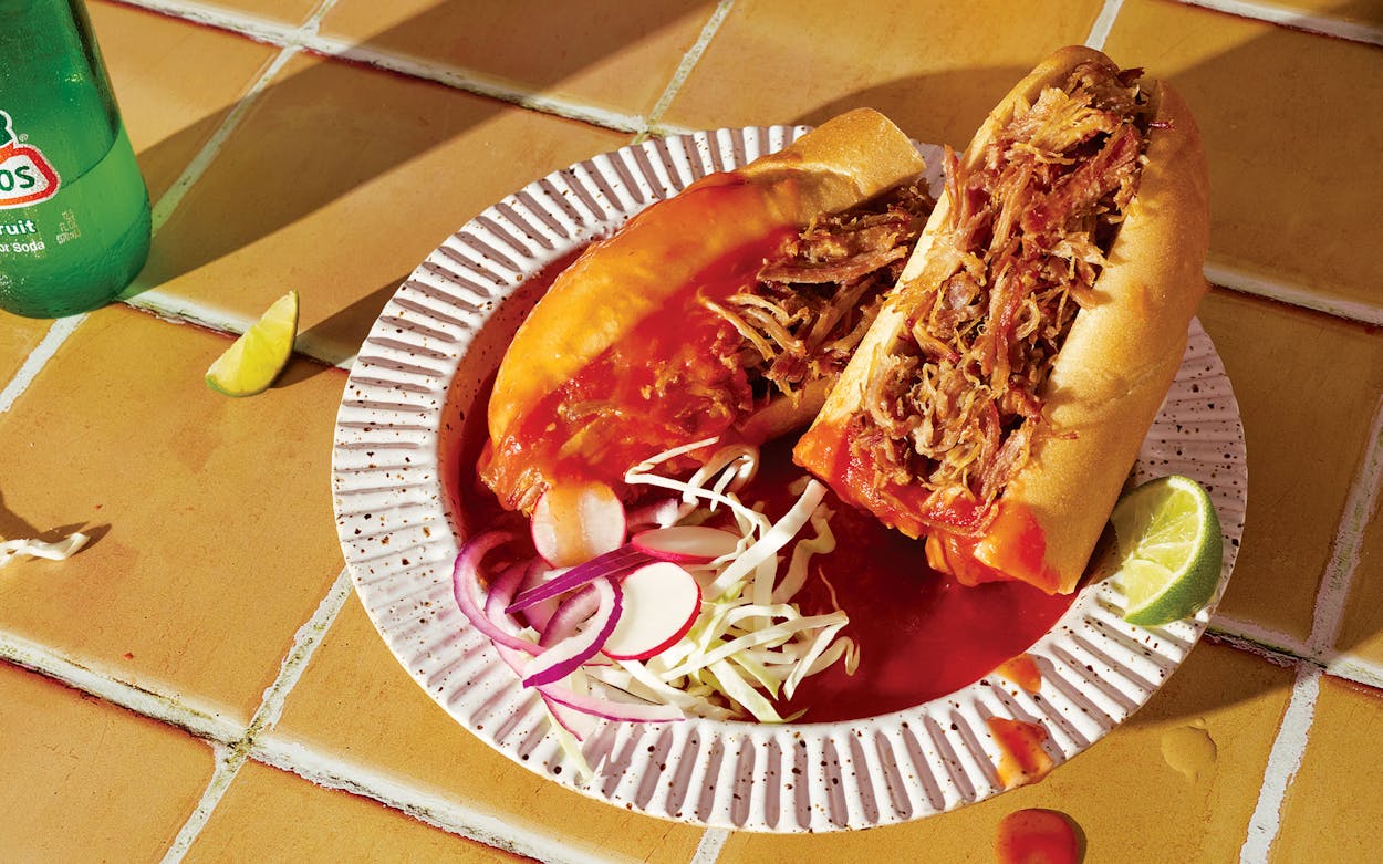 Torta ahogada stuffed with carnitas and smothered in salsa.