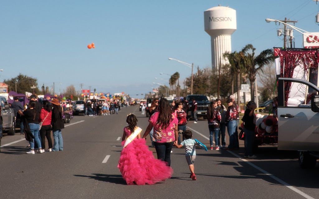 Young festival royalty and her family walk down the parade route during setup in Mission, TX during the annual Texas Citrus Fiesta on January 27, 2024.