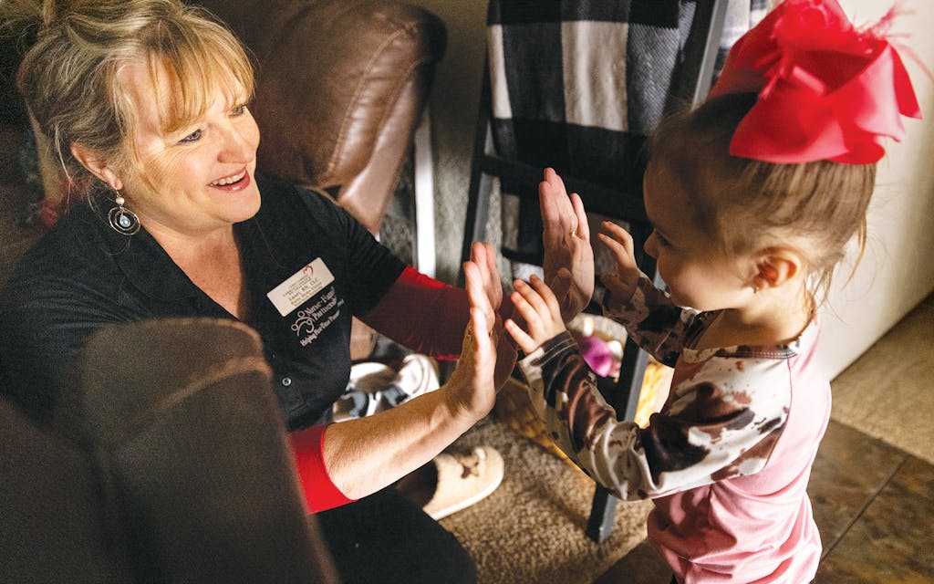 Nurse Lauri Mannon giving a high five to two-year-old Brynleigh Cartner.