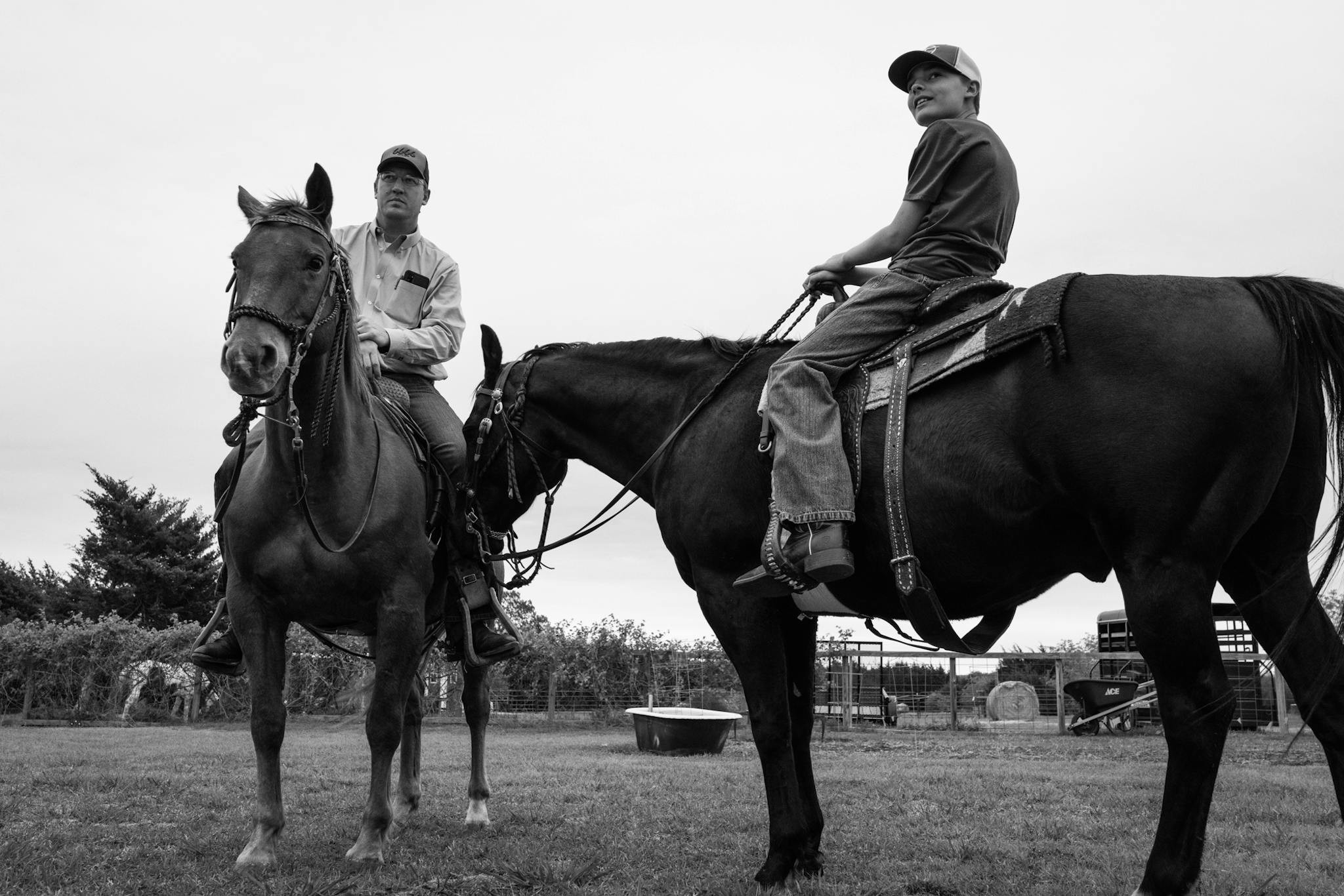 Curtis horseback with one of his sons outside their home.
