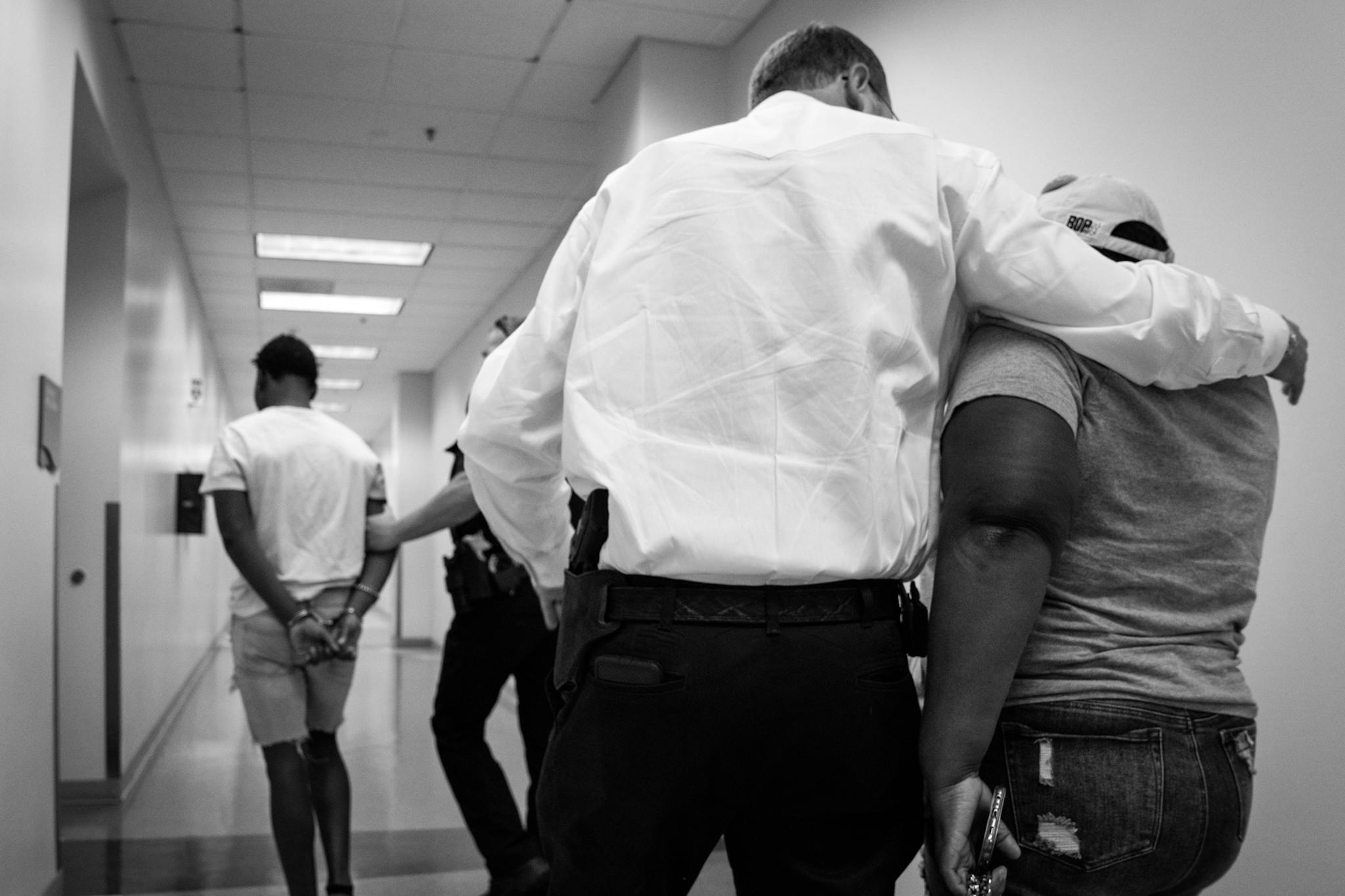Curtis comforting a mother as her juvenile son is arrested for suspected homicide