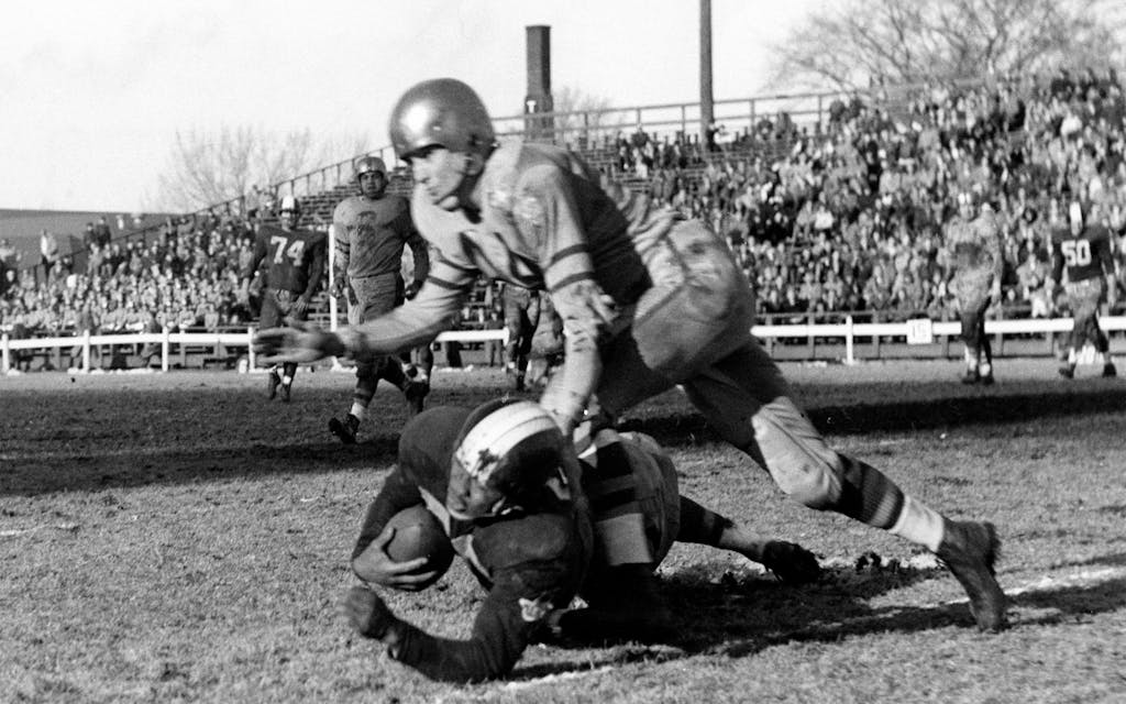 Green Bay Packers defensive back Bobby Dillion (44) stops Dallas Texans running back George Taliaferro (20) during an NFL game in Green Bay, Wisc., on Nov. 23, 1952.