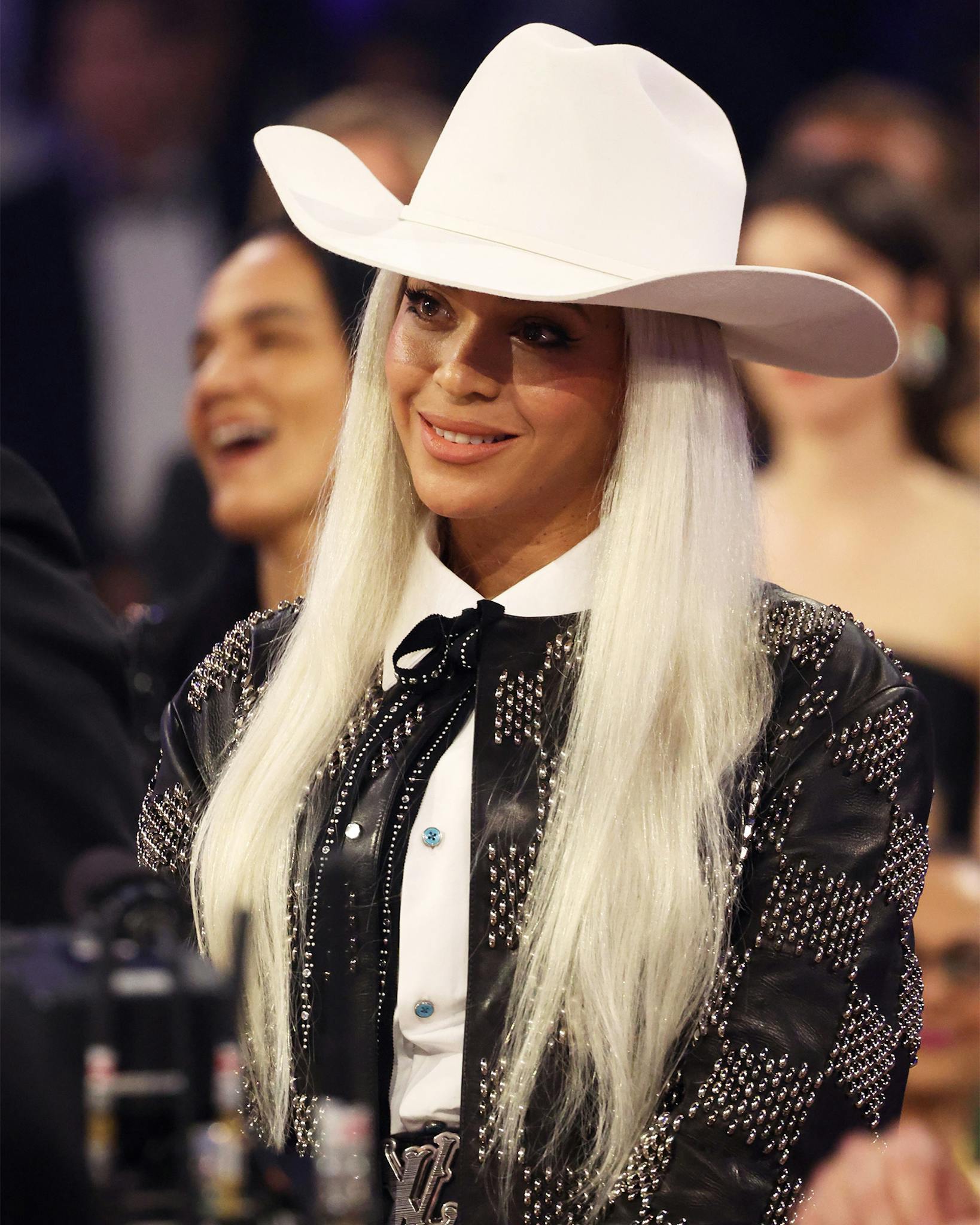 Beyoncé fully committed to her Western getup but with her own spin. The two-piece Louis Vuitton black leather and stud checkered blazer set is equally chic and glamorous, paired with a bow-meets-bolo tie (the accessory of the year) and a comically big white Cowboy hat that was her instant giveaway in the crowded room of stars. 