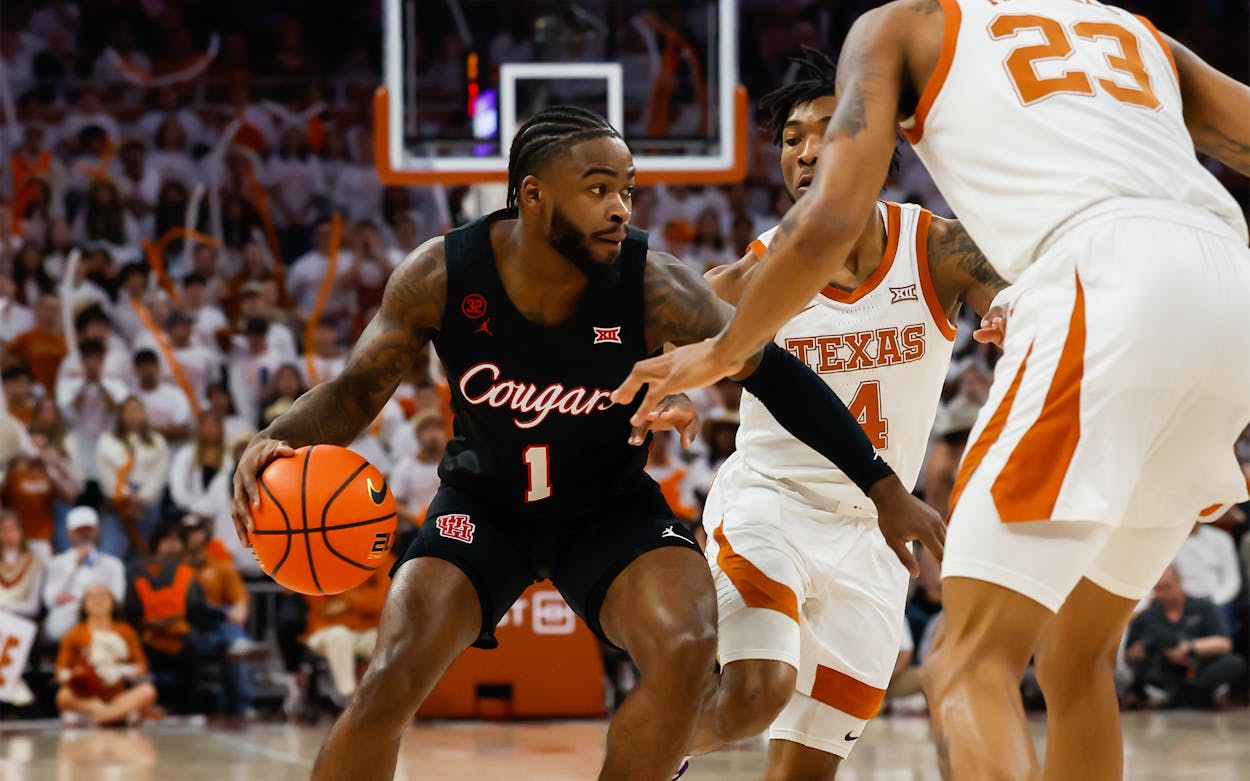 Houston Cougars guard Jamal Shead (1) controls the ball while being guarded by Texas Longhorns forward Dillon Mitchell (23) and Texas Longhorns guard Tyrese Hunter (4) during the Big 12 college basketball game between Texas Longhorns and Houston Cougars on January 29, 2024, at Moody Center in Austin, Texas.