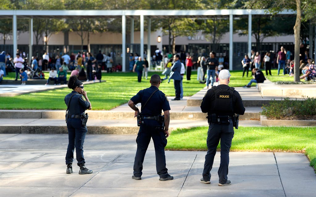 Houston Police officers watch over displaced churchgoers outside Lakewood Church, in Houston, on Sunday, February 11, after a reported shooting during a Spanish church service.