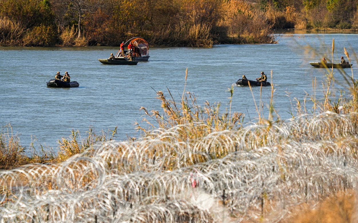 Guardsmen move along the Rio Grande in small boats past rows of concertina wire placed to help curb illegal crossings on February 1, 2024, in Eagle Pass.