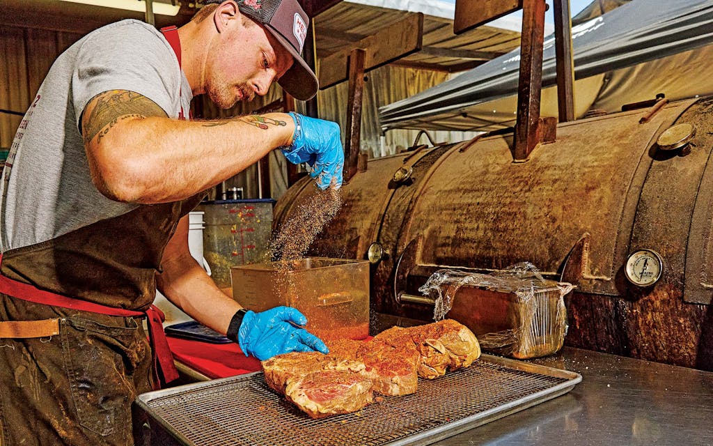 Owner Phillip Helberg seasons citrus pork steaks at Helberg Barbecue, in Woodway.
