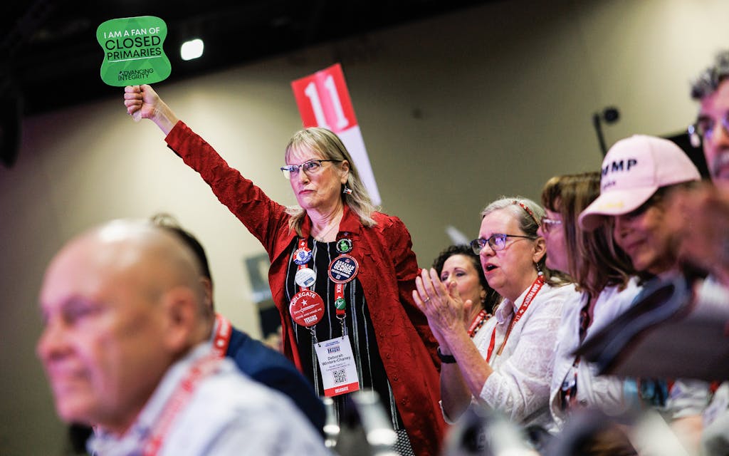A woman holds a sign supporting closed primaries during a speech at the 2024 Texas State Republican Convention in San Antonio on May 23, 2024.