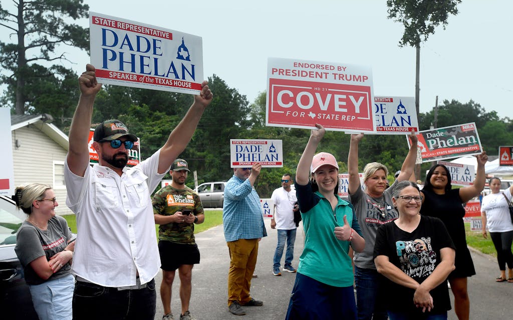 Supporters for Texas State House District 21 candidates Dade Phelan and David Covey vie to have their signs seen while Covey speaks with the media at the Raymond Gould Community Center in Vidor, Texas, Tuesday, May 28, 2024.