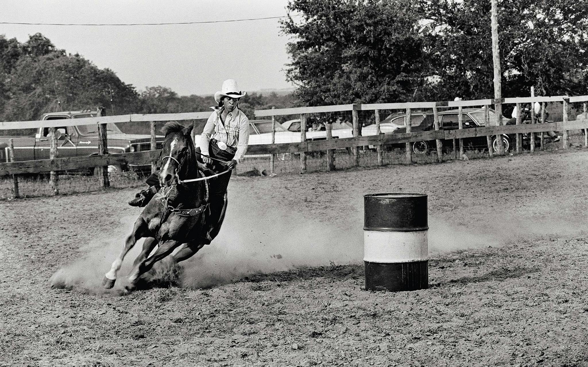 Barrel racer Earnestine Rogers rounding the third barrel and preparing to take it home in the summer of 1979, near El Campo.