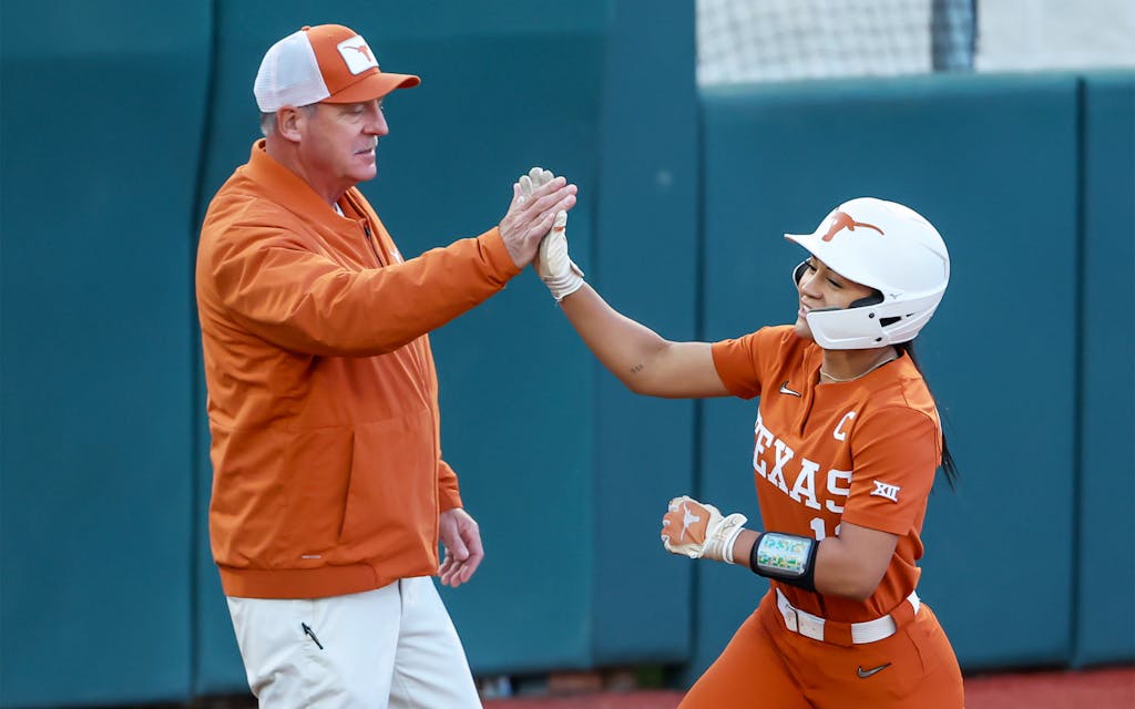 Texas infielder Alyssa Washington high-fiving head coach Mike White after a home run during a game in March.