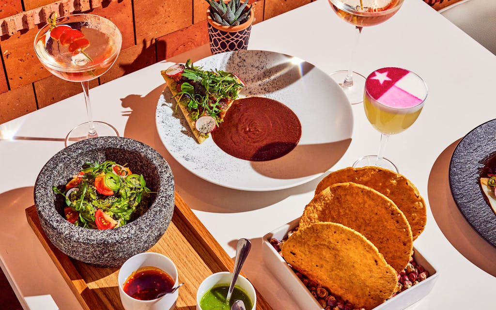 A spread including guacamole, a margarita that blends mezcal and champagne, and the flag-adorned Santana Sour.