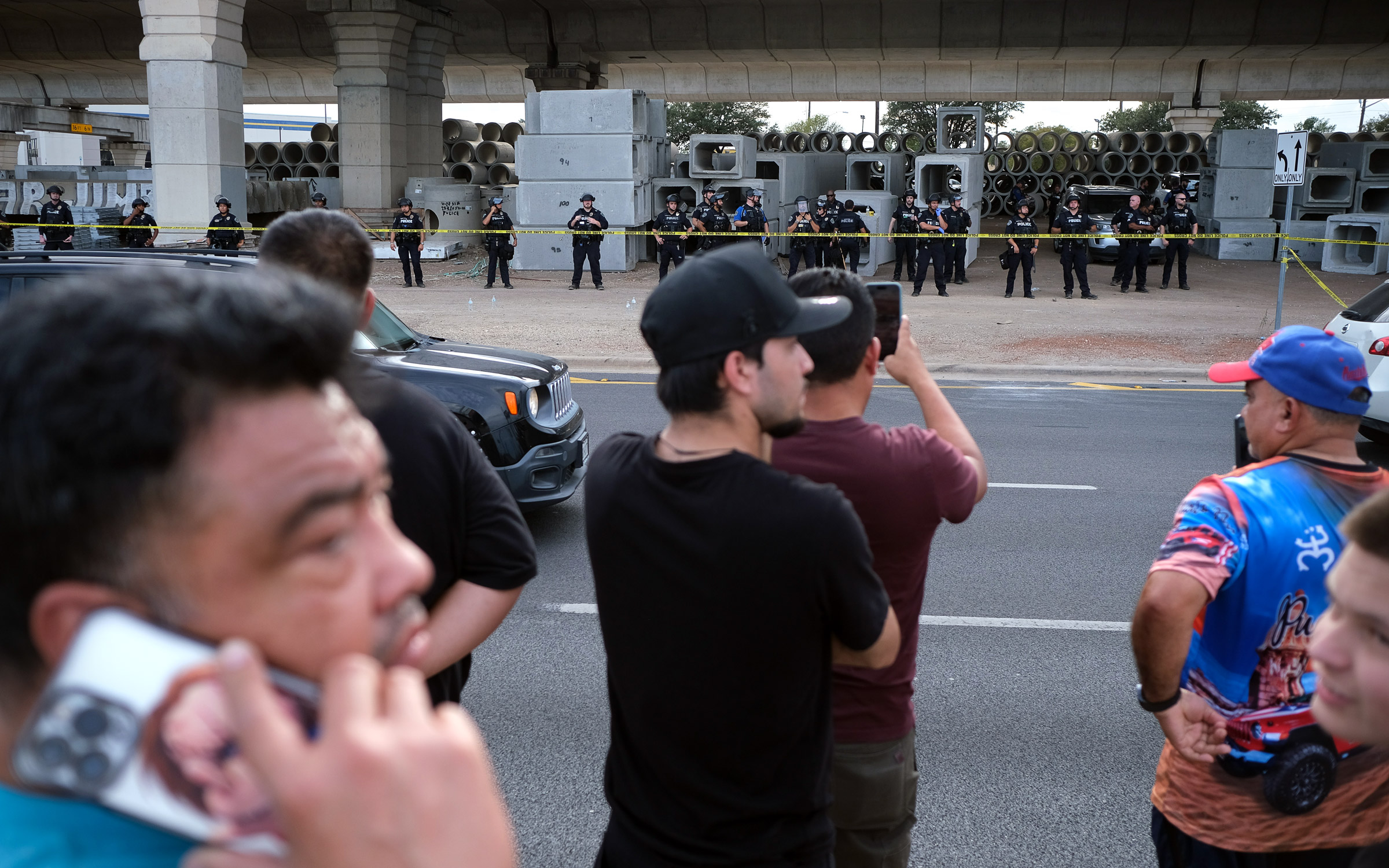 People gather where local authorities say an ICE officer shot and wounded a man in Austin on September 20, 2026.