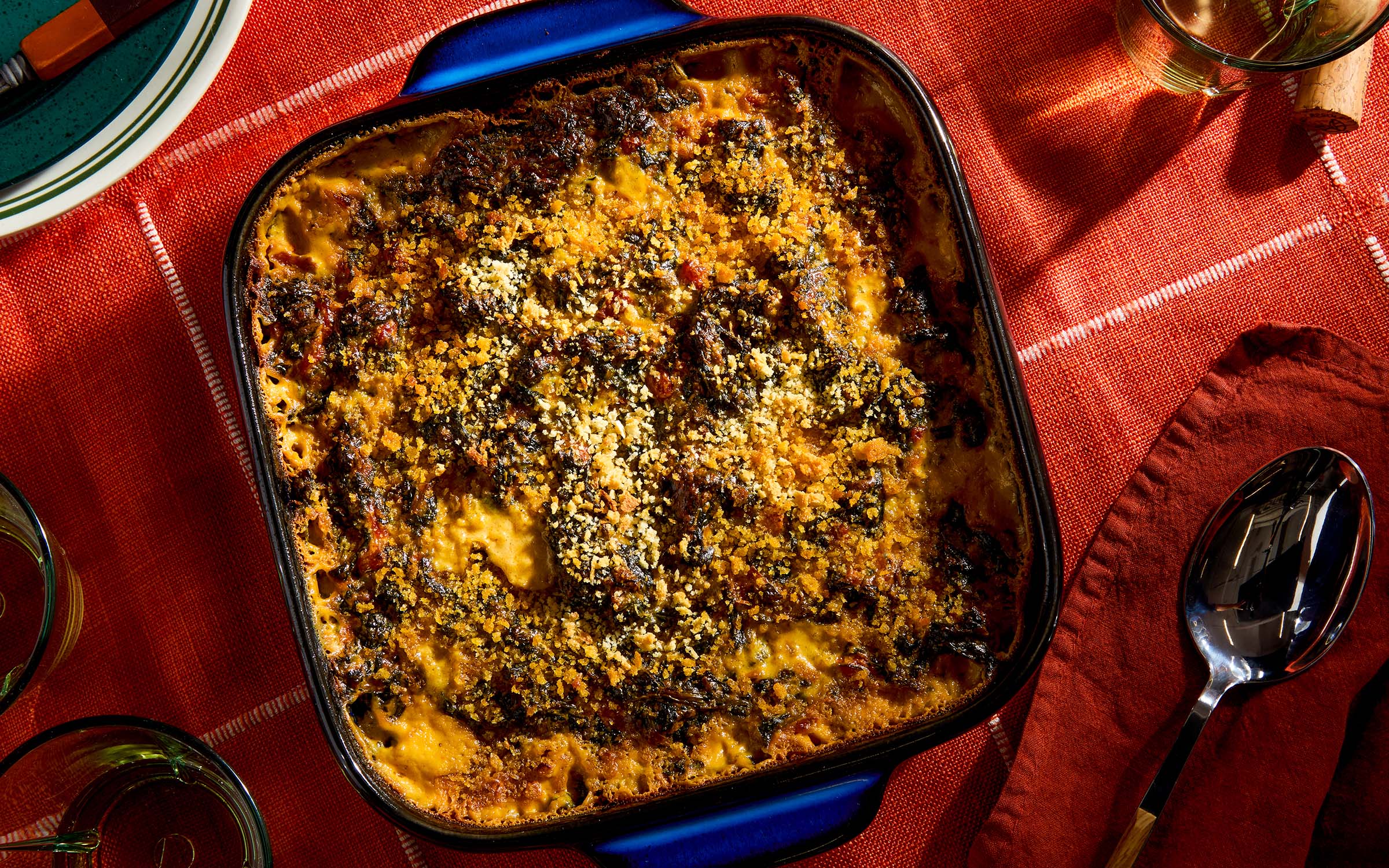 A pan of queso creamed spinach on a red tablecloth